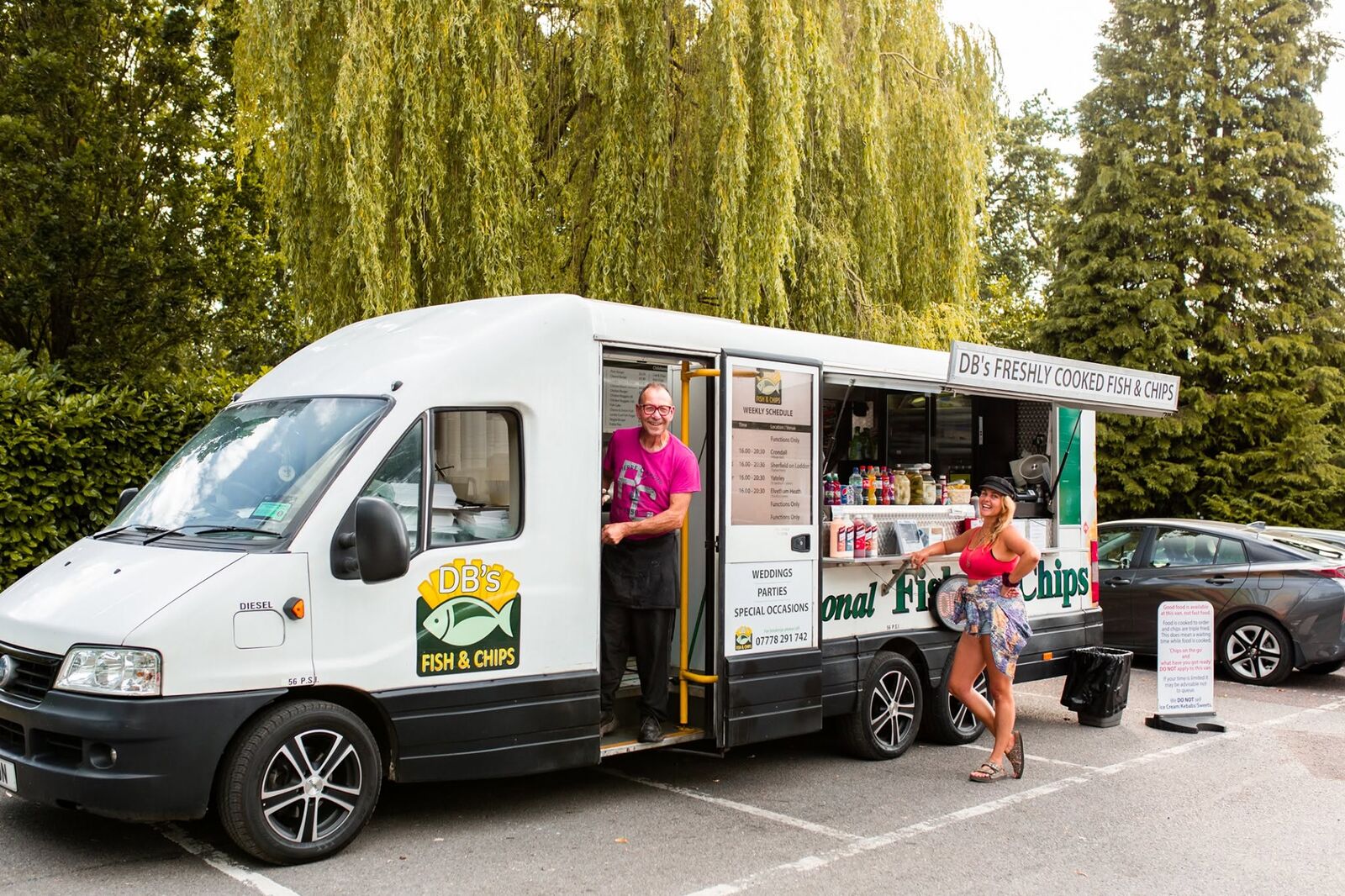DB's Fish & Chips van parked up with its serving hatch open and David waving from the door